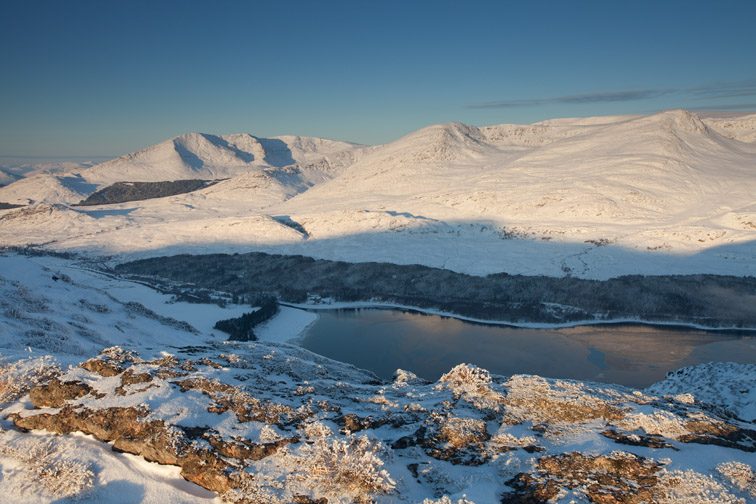 View over Loch Laggan of Creag Megaidh and surrounding mountains in winter,with Binnein Shuas in foreground, Badenoch, Scotland, UK
